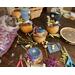 This is my work table showing the custom hats being made for the decorative gourds. It shows cut fabric and dried berries used on the hats. 